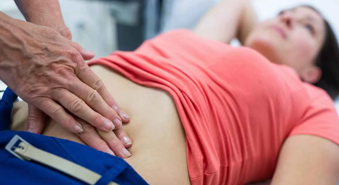 doctor examinando abdomen de mujer