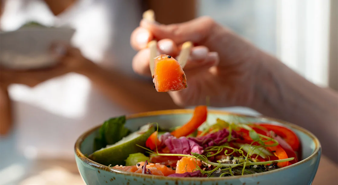 plato de comida saludable con mano de mujer