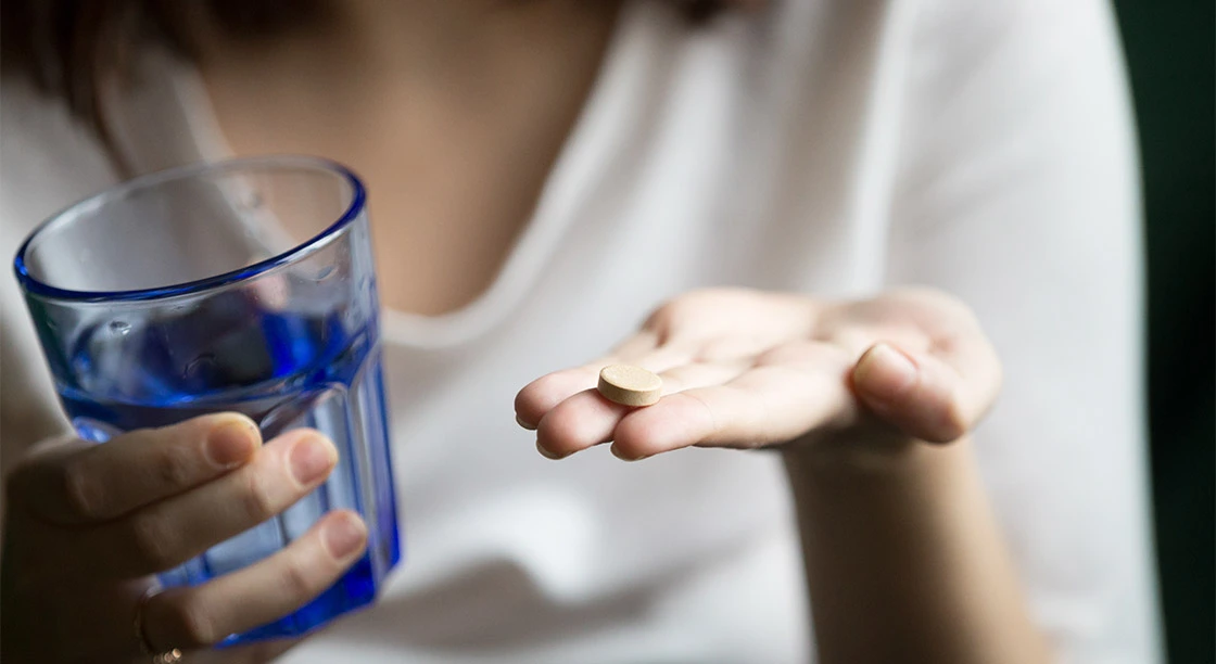 mujer mostrando vasoy medicamento