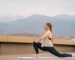 Young sportswoman is doing yoga exercise on rooftop of parking, garage in summer day morning.